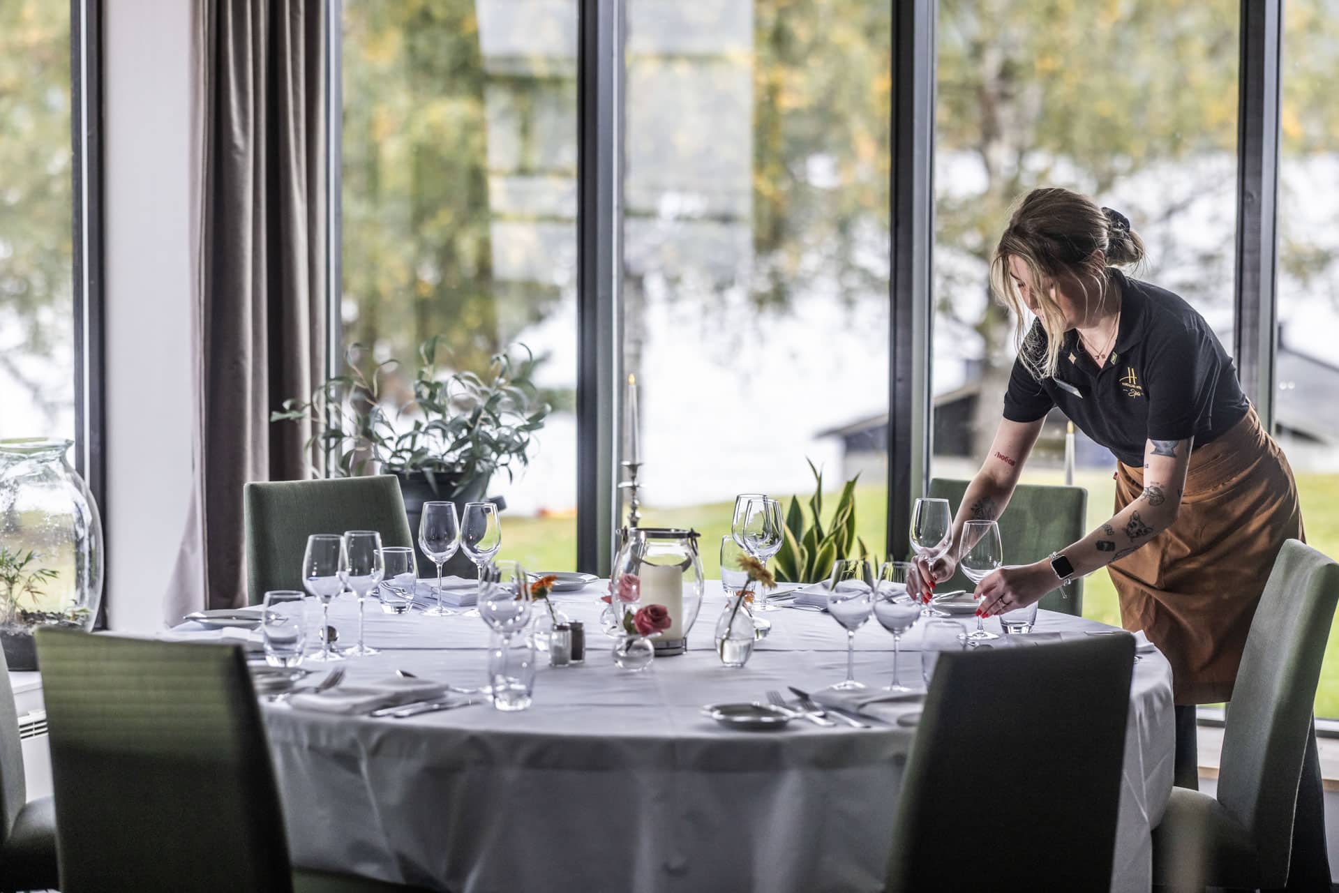 Servitør dekker bord i restauranten Utsikten