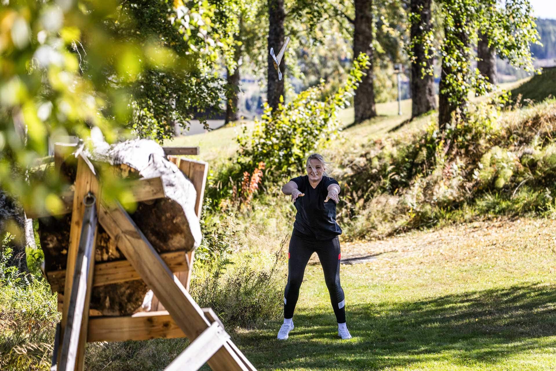 Gjester prøver øksekast under teambuilding ved Hurdalsjøen